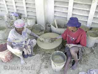 Two Haitian women sifting the clay for té